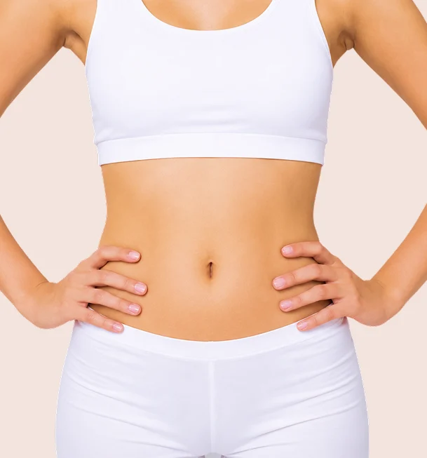 Ventre plat d'une femme en brassière et short blancs, mains sur les hanches