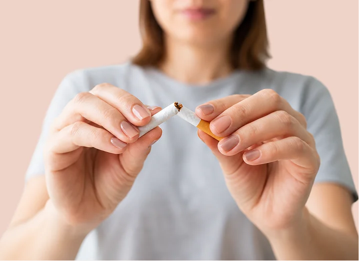 Femme brisant une cigarette en deux entre ses mains