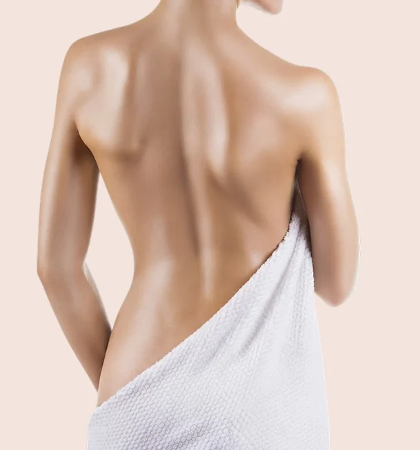 Dos nu d'une femme enveloppée d'une serviette blanche, vue de trois quarts