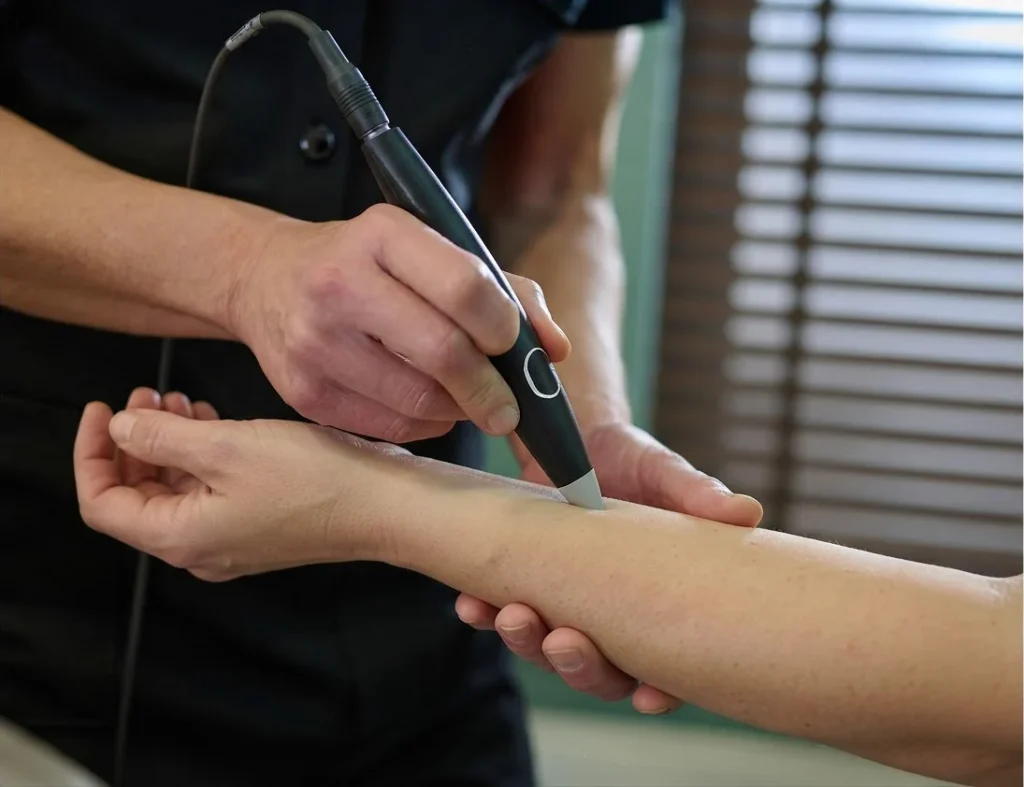 Johana applique le stylet de Luxopuncture® sur l'avant-bras d'une cliente