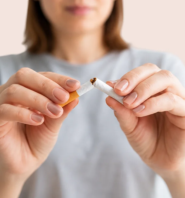 Femme en t-shirt gris qui casse une cigarette en deux